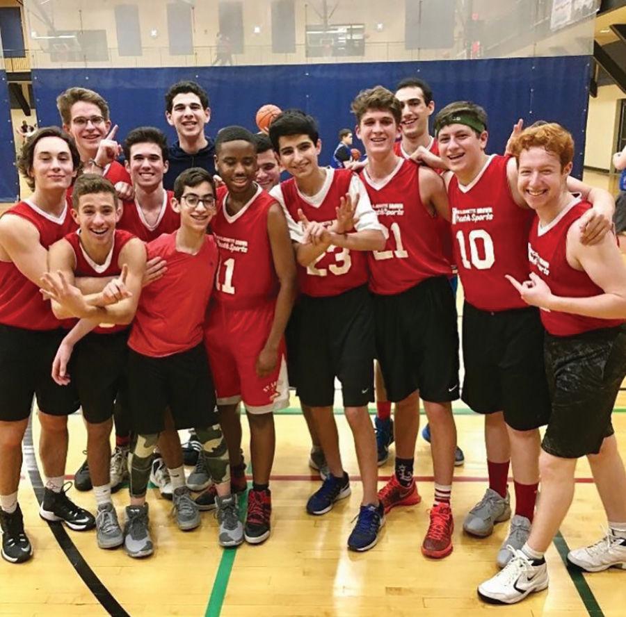 Members of the Latke Flocka Flame team in the J’s basketball league storm the court after a game. 