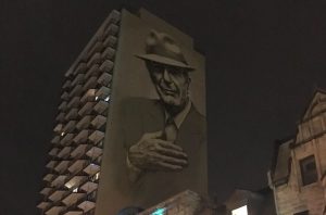 A painting of Leonard Cohen towers above Crescent Street in downtown Montreal. (Ben Harris)