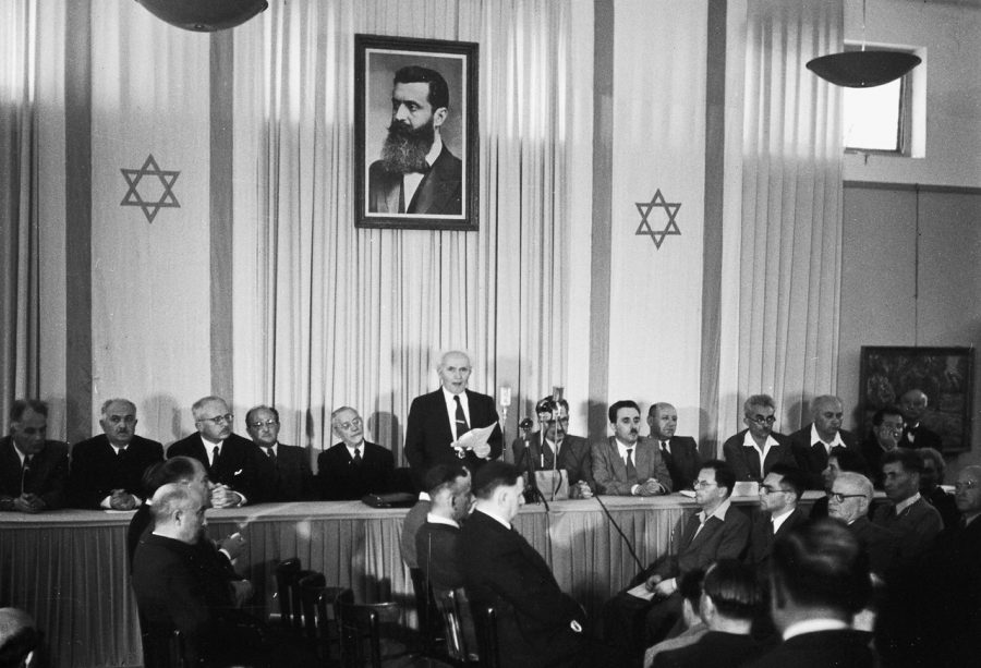 David Ben-Gurion (First Prime Minister of Israel) publicly pronouncing the Declaration of the State of Israel, May 14 1948 in Tel Aviv, beneath a large portrait of Theodor Herzl, founder of modern political Zionism, in the old Tel Aviv Museum of Art. Photo: Rudi Weissenstein/Israel Ministry of Foreign Affairs