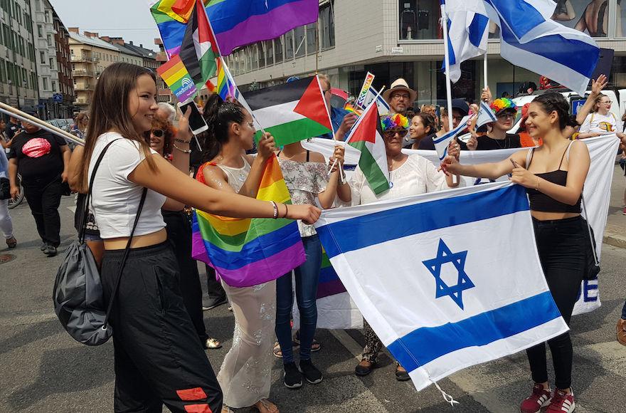 Ilana Edner, marching behind the Israeli flag, with participants of the Jewish contingent of the gay pride parade in Malmo, Sweden, June 10, 2018. (Cnaan Liphshiz)