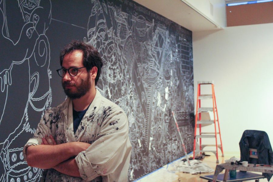 Israeli-American artist Edo Rosenblith examines the progress of his mural in COCA’s Millstone Gallery on May 29. 