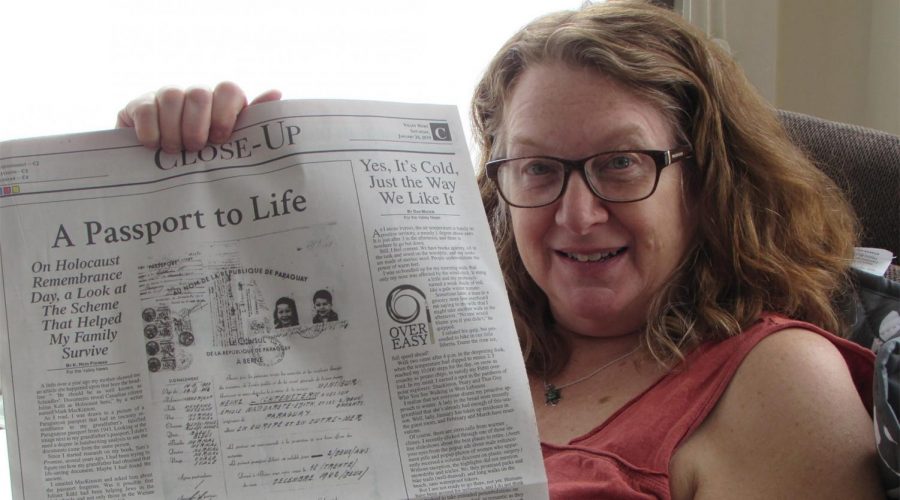 Heidi Fishman holding up an op-ed she wrote about her family’s rescue from the Holocaust using a Paraguayan passport. (Courtesy of Fishman)