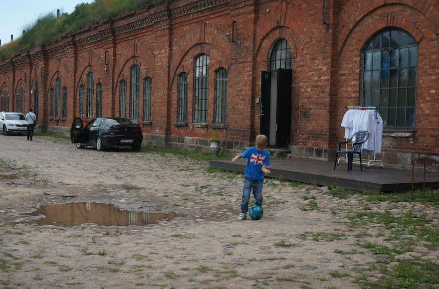 A+boy+playing+soccer+at+the+entrance+to+the+former+concentration+camp+known+as+the+Seventh+Fort+in+Kaunas%2C+Lithuania%2C+on+July+12%2C+2016.+%28JTA%2FCnaan+Liphshiz%29