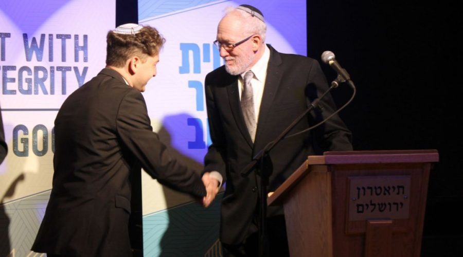 Newly ordained Rabbi Daniel Atwood is congratulated by Rabbi Daniel Landes at the Jerusalem Theater on May 26, 2019. (Sam Sokol)  