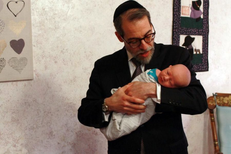Rabbi+Michael+Rovinsky+holds+a+child+after+a+circumcision+at+a+clinic+in+Russellville%2C+Mo.+Photo%3A+Eric+Berger