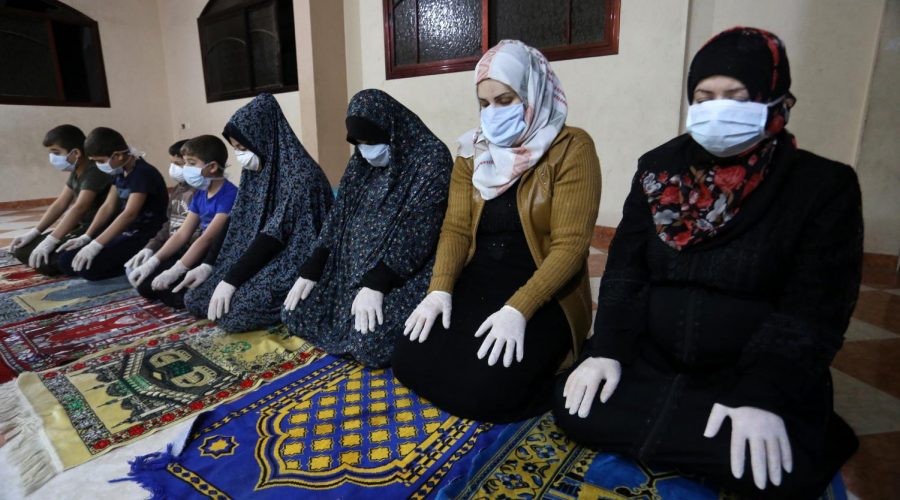 A Palestinian family in Gaza wearing protective masks prays on the first night of Ramadan in their home because of the closure of mosques due to coronavirus restrictions, April 23, 2020. 