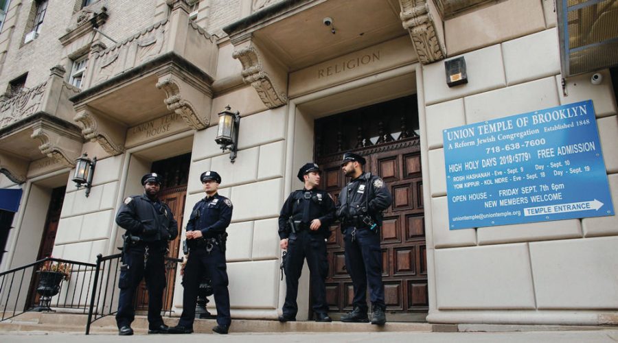 New York police officers stand guard at the door of the Union Temple of Brooklyn after it was vandalized with graffiti, Nov. 2, 2018.  