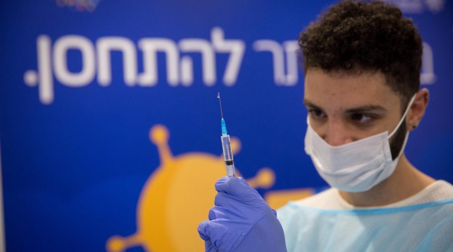 A healthcare worker prepares a vaccine at a facility operated by the Tel Aviv Sourasky Medical Center in Rabin Square, Dec. 31, 2020. (Miriam Aster/Flash90) 