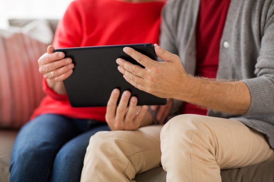 close up of senior couple with tablet pc at home