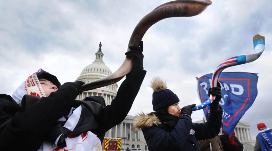 Two women, one wearing a tallit, blow the shofar amid the Capitol rioting, Jan. 6, 2021. Photo: Lloyd Wolf