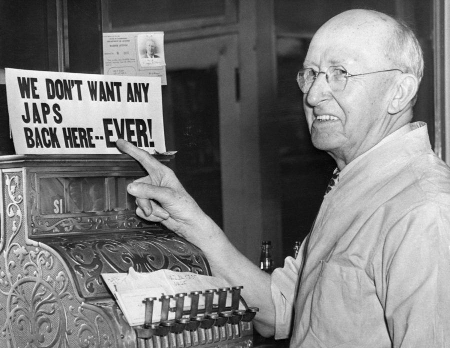 After the internment of Japanese Americans from the Seattle region, barber G.S. Hante points proudly to his bigoted sign reading We Dont Want Any Japs Back Her..EVER!.