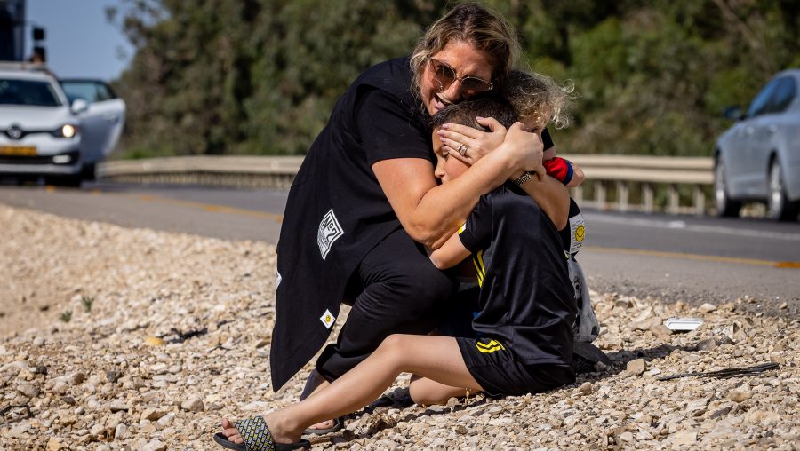 A woman and child take cover as a siren sounds a warning of incoming rockets fired from the Gaza strip on a road between Ashkelon and Sderot, southern Israel, on May 19, 2021.(Olivier Fitoussi/Flash90)
