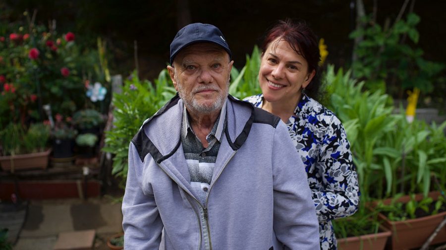 Vitali Voskoboinik stands with his daughter, Yulia Nedzvetski, in the garden of his home at Terrace Senior Housing in Pacifica. (Photo/Lea Loeb)
