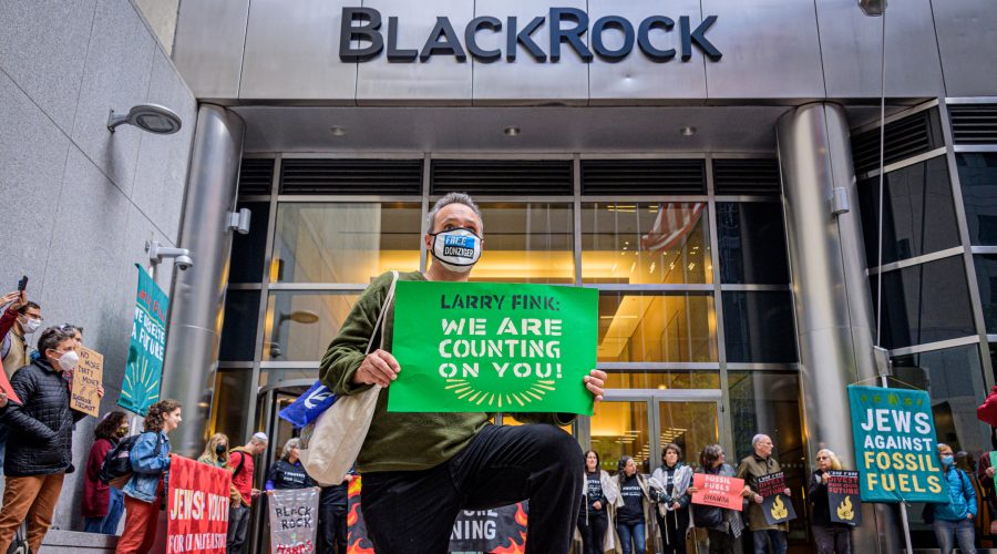 A demonstrator kneels in front of the headquarters of BlackRock in Manhattan, demanding the investment firms  CEO Larry Fink defund the fossil fuel industry, Oct. 18, 2021. (Erik McGregor)