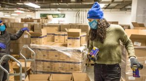 A volunteer helps package emergency food deliveries for Holocaust survivors at the Greenpoint, Brooklyn Fulfillment Center of the Metropolitan Council on Jewish Poverty, a beneficiary agency of the UJA-Federation of New York, Jan. 18, 2021. (Met Council)