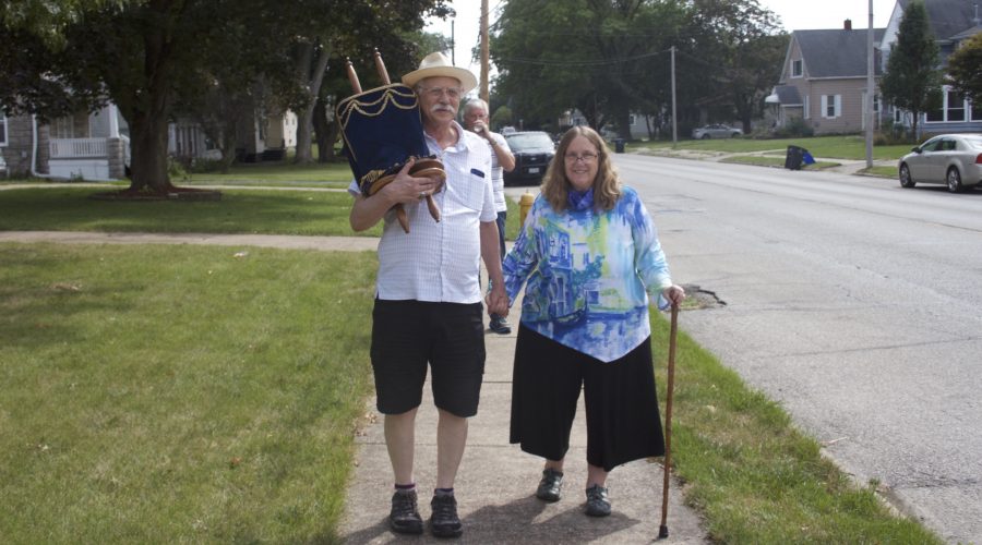 Rabbi Linda Bertenthal (right) and her husband Philip carry their congregations Torah on its 7.5-mile journey across the Mississippi River, from Rock Island, Illinois, to its new home in Davenport, Iowa. (Beit Shalom Jewish Community)