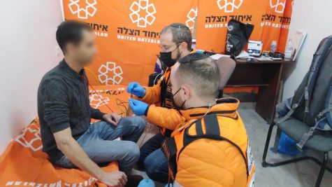 Avi Marcus together with another EMT Yechiel Gurfein treating a refugee at the medical clinic in Chisinau