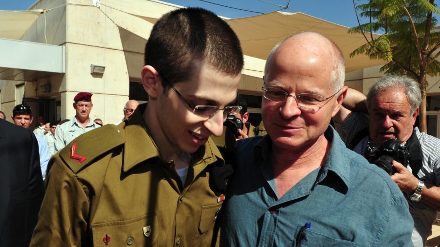 In this handout photo provided by the Israel Defenses Force, freed Israeli soldier Gilad Shalit (L) walks with his father Noam Shalit at Tel Nof Airbase, Oct. 18, 2011. (Israel Defense Forces via Getty Images)