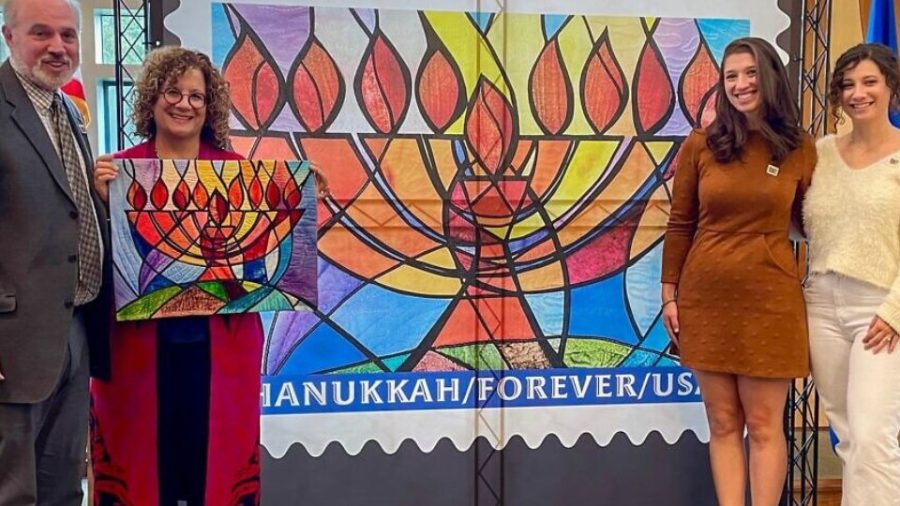 The “Hanukkah Forever” postage stamp is unveiled at Temple Emanu El in Orange Village, Ohio, on Oct. 20. Second from left is designer Jeanette Kuvin Oren. Credit: Courtesy Jeanette Kuvin Oren.