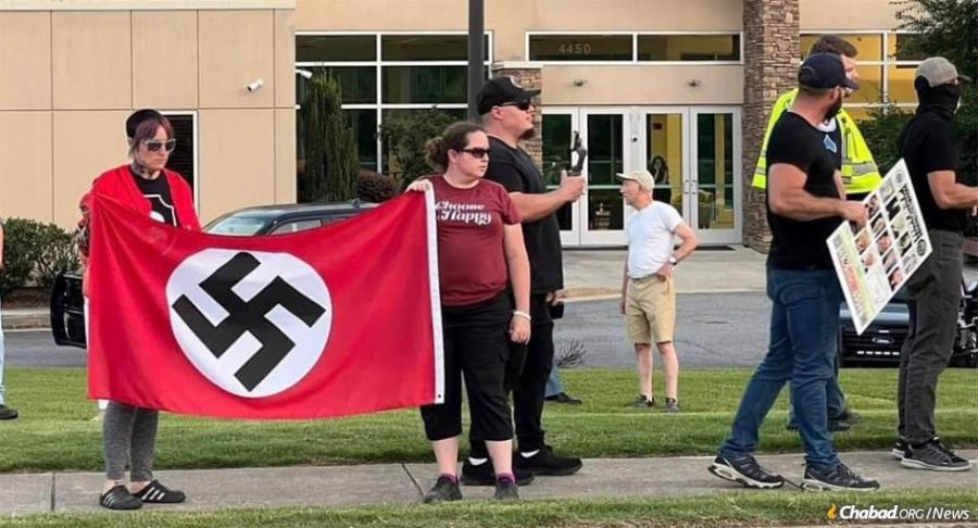 On Shabbat afternoon, as people were arriving for afternoon services at Chabad-Lubavitch of Cobb County, in Marietta. Ga., they were confronted by 12 members of an antisemitic hate group brandishing antisemitic posters and swastika flags outside the synagogue.
Photo by Jennifer Caron Derrick/Facebook