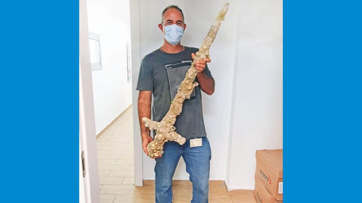 Nir Distelfeld, inspector for the Israel Antiquities Authority, with the Crusader sword. Photo by Anastasia Shapiro, Israel Antiquities Authority