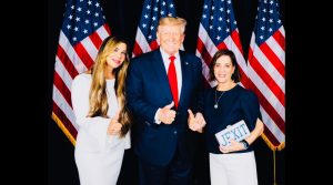 Siggy Flicker, left, poses with former president Donald Trump, center. 