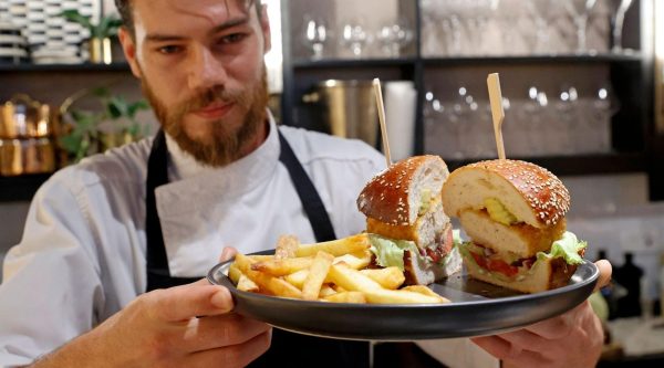 Israeli chef Shachar Yogev serves a burger made with cultured chicken meat at The Chicken, SuperMeats restaurant adjacent to their production site in the Israeli town of Ness Ziona on June 18, 2021. 