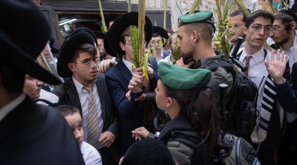 Israeli border police stand guard near Orthodox Jews in the Old City’s Christian quarter, after an incident in which Haredi Orthodox Jews spat at a Christian procession carrying a cross through Jerusalems Old City. 