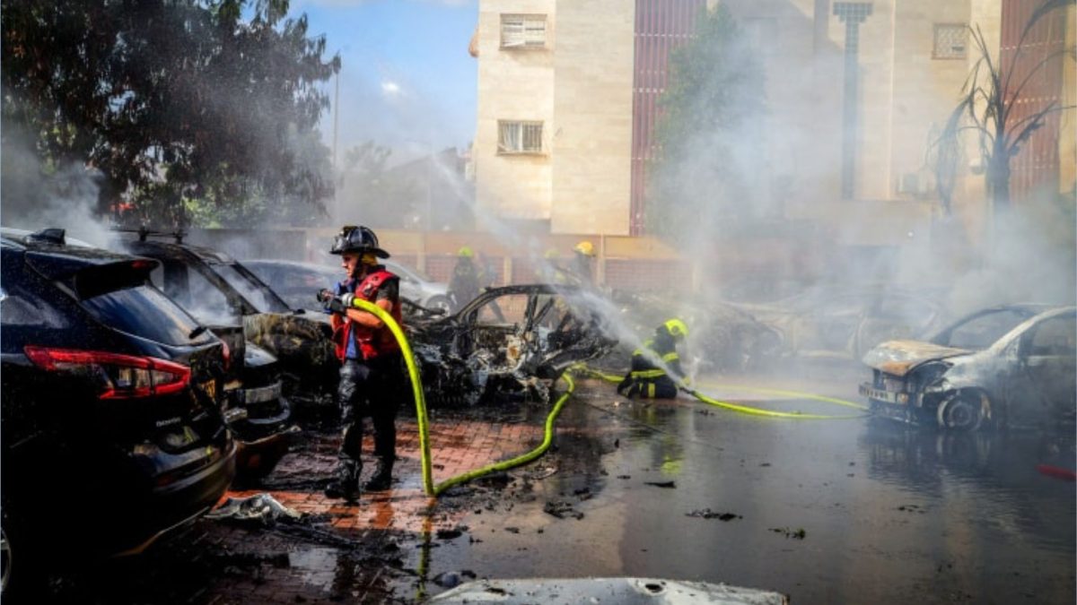 Firefighters tackle burning cars set aflame by a Gazan rocket in Beersheva, Oct. 7, 2023. 