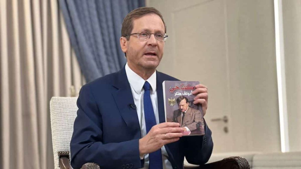 Israeli President Isaac Herzog holds up a copy of an Arabic translation of "Mein Kampf" that was found by IDF troops in a children's room used as a Hamas terror base in the Gaza Strip, Nov. 12, 2023. 