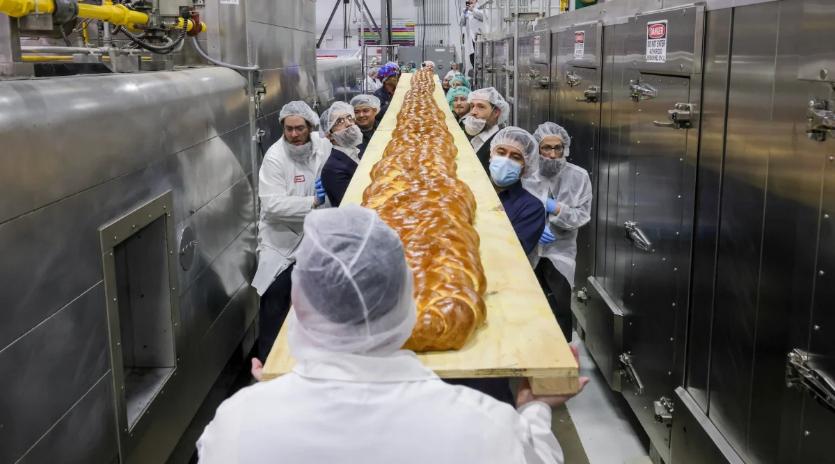 The 35 foot long challah was baked in a tunnel oven at Davids Cookies in New Jersey. It was then loaded onto a wooden plank and transported to the Upper West Side where it was unveiled at a day schools Shabbat assembly. (JFNA/Vladimir Kolesnikov)