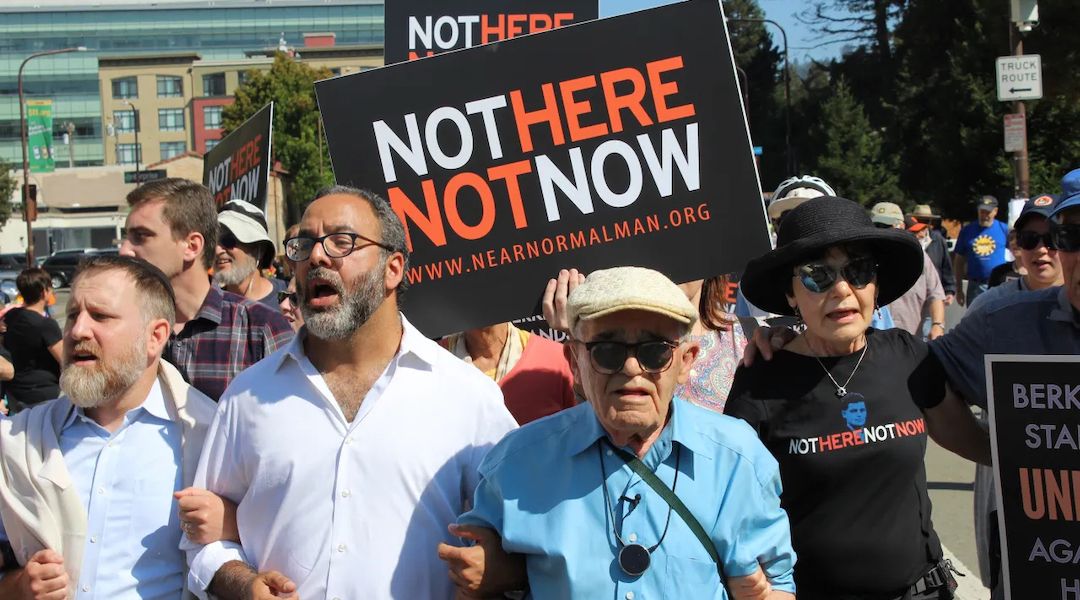 Holocaust survivor Ben Stern (blue shirt) leads 200 marchers in the Bay Area Rally Against Hate in Berkeley in August 2017. He is linking arms with his daughter Charlene Stern and Rabbi Menachem Creditor; Rabbi Yonatan Cohen of Congregation Beth Israel in Berkeley is at far left. (Rob Gloster/J.)