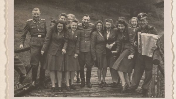 Women’s auxiliaries and SS officers enjoy music not far from the barracks of Auschwitz-Birkenau. 
