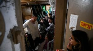 People take cover in a stairway in Jerusalem, as a red alert is sounded when drones and missiles fired from Iran neared Israel, April 14, 2024. 
