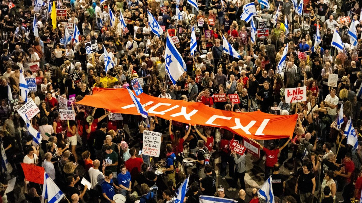 Thousands of Israeli demonstrators in an anti-government protest call for a hostage deal and ending the war, Tel Aviv, May 18, 2024. The sign in Hebrew reads, "Mother is here." (Yahel Gazit/Middle East Images/AFP via Getty Images)