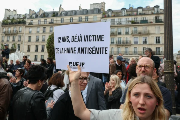 A protester holds a placard which reads as Twelve-year-old and already a victim of antisemitic hate as she gathers to condemn the alleged antisemitic gang rape of a 12-year-old girl, at the Paris City Hall square, June 19, 2024. Alain Jocard/AFP via Getty Images)