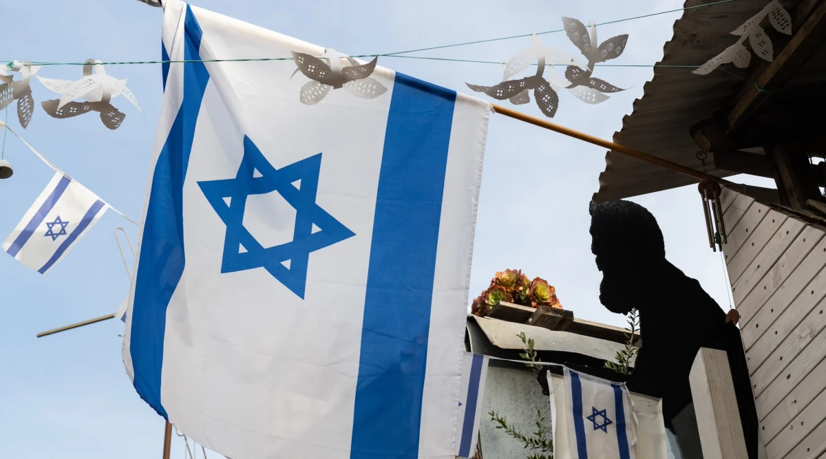 A silhouette of Theodor Herzl, the founder of modern Zionism,  is displayed near a flag of the state of Israel on a building in Jerusalem. (Yehoshua Halevi/Getty Images)