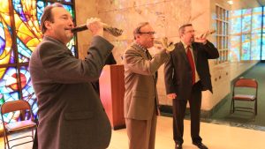 Rob Loewenstein (center) and his sons, Michael (left) and Drew, sound the shofar during a service of remembrance at New Mount Sinai Cemetery in 2018 (this year’s service takes place Oct. 6).  File photo: Bill Motchan