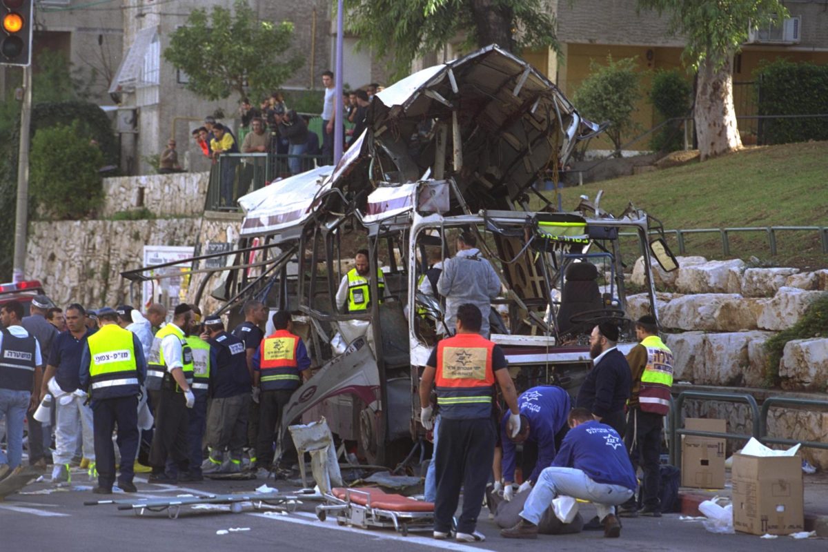 Security and rescue forces work on the remains of the bus destroyed by a suicide bomber in Haifa on Dec. 2, 2001. By Moshe Milner, Israeli Government Press Office, CC BY-SA 3.0