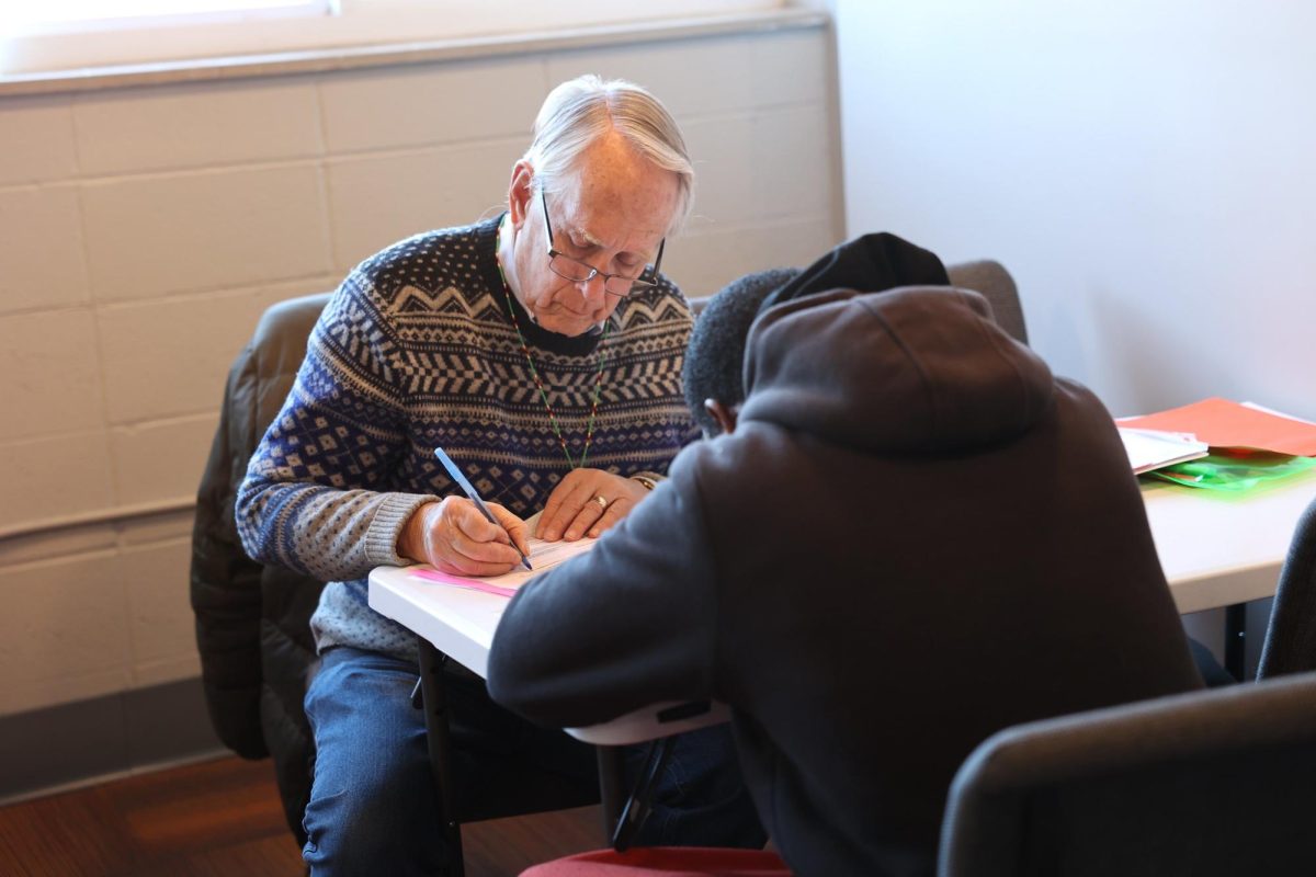 An Ashrei Foundation volunteer Bill Rowe fills out paperwork to assist an individual in applying for a Missouri photo ID.  

