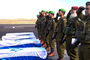 Israeli soldiers salute as they receive the coffins with the bodies of deceased hostages Oded Lifschitz, Shiri Bibas and her two children Kfir and Ariel Bibas, who were kidnapped during the deadly October 7, 2023 attack by Hamas, and were handed over under the terms of a ceasefire between Hamas and Israel, in the Gaza Strip in this handout image obtained by Reuters on February 20, 2025. GPO/Handout via REUTERS