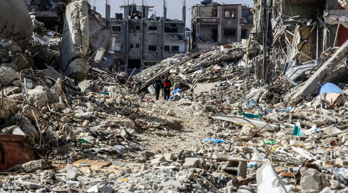 Palestinians walk along destroyed houses at the Shaboura area in the center of Rafah, days into the ceasefire agreement between Israel and Hamas, Jan 24, 2025.