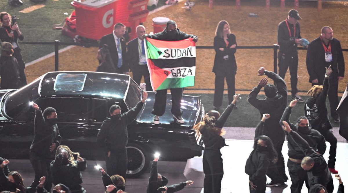 A protester holds a Sudan/Palestinian flag with the words "Gaza" and "Sudan" as US rapper Kendrick Lamar performs during thee Super Bowl LIX halftime show, Feb. 9, 2025. 