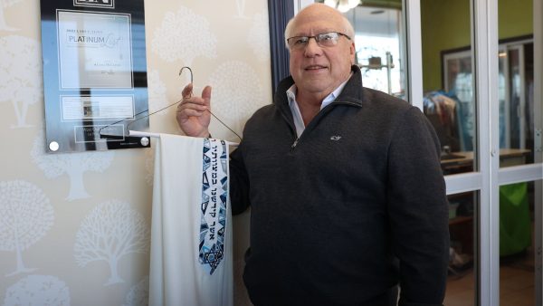 Warren Schultz, owner of West Oak Cleaners, holding a Tallit.