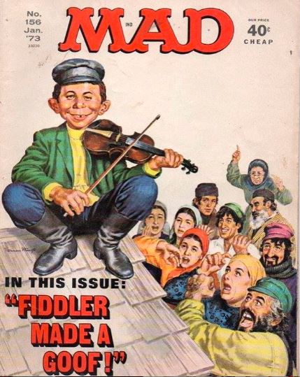 Back in January 1973, MAD magazine took its famously goofy aim at one of the most beloved Jewish musicals of all time—Fiddler on the Roof. On the cover of issue No. 156, Alfred E. Neuman is perched on a rooftop, violin in hand, beaming like only he can while shtetl townsfolk scream in terror below. The headline? “Fiddler Made a Goof!” It’s peak MAD—equal parts parody and pop culture time capsule. By this point, Fiddler was a Broadway smash and a hit film, so naturally, MAD had to send Alfred to Anatevka to mess it all up.