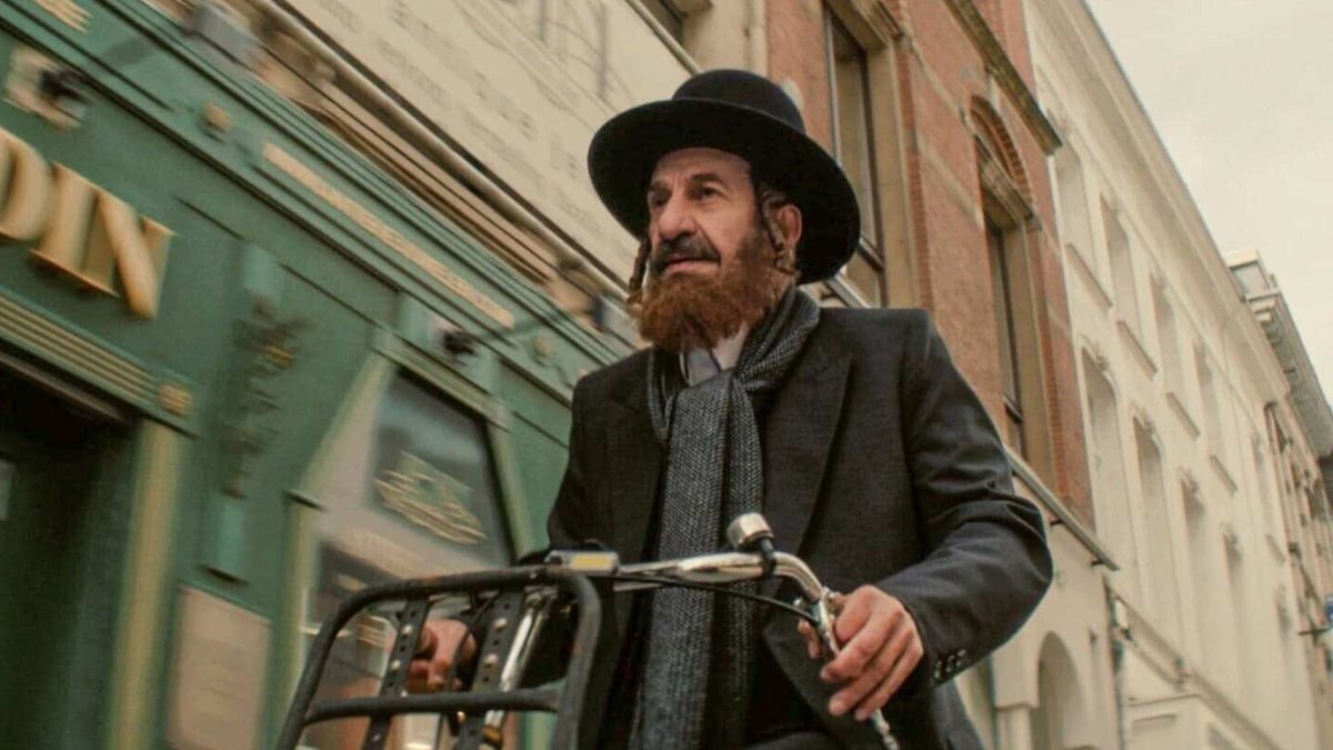 Nuchem Shtisel (played by Sasson Gabay) rides a bicycle through Amsterdam in “Kugel.” Credit: Courtesy of IZZY.