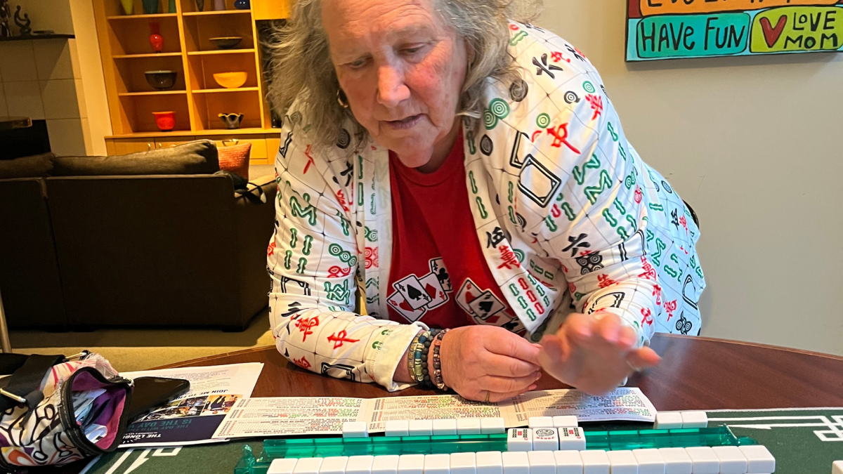 Phyllis Siegel leads newbies learning mahjong dressed in one of her signature mahj shirts.
