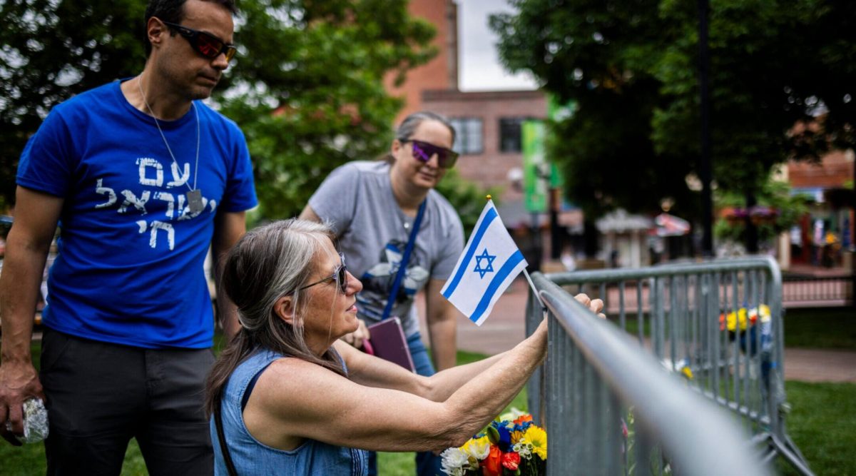 Lisa Turnquist of Louisville, Colorado, lays flowers and a flag at the site of the attack outside the Boulder County Courthouse on June 2, 2025 in Boulder. (Chet Strange/Getty Images)