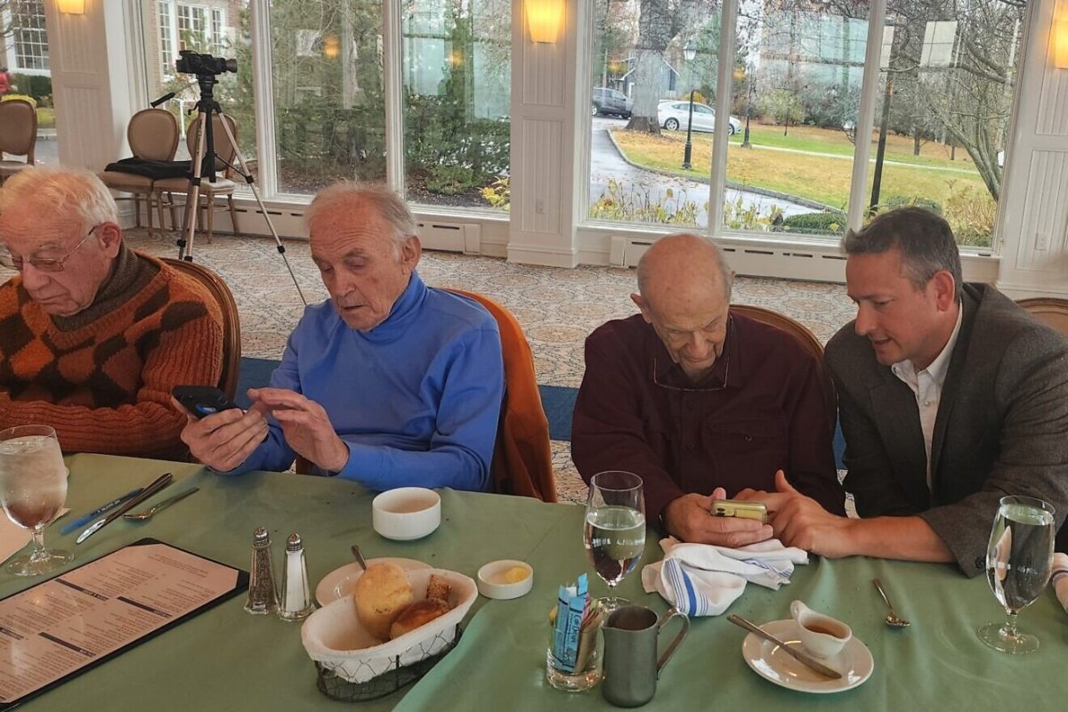 Dan Rosen (right), co-founder and co-chair of the new Emissary app, teaches Jewish community members how to use it. Credit: Courtesy.