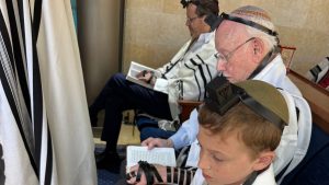 Heschel Raskas (center) and his grandson, Aaron Raskas, take part in morning minyan with Israeli President Isaac Herzog last month in Israel, a few days before Aaron’s bar mitzvah.